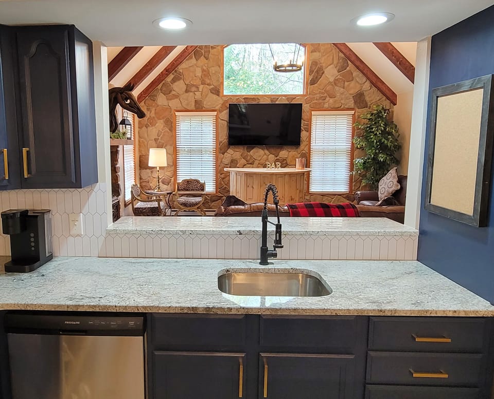 The view from the kitchen sink, you can clearly see the 65" TV and bar area.
