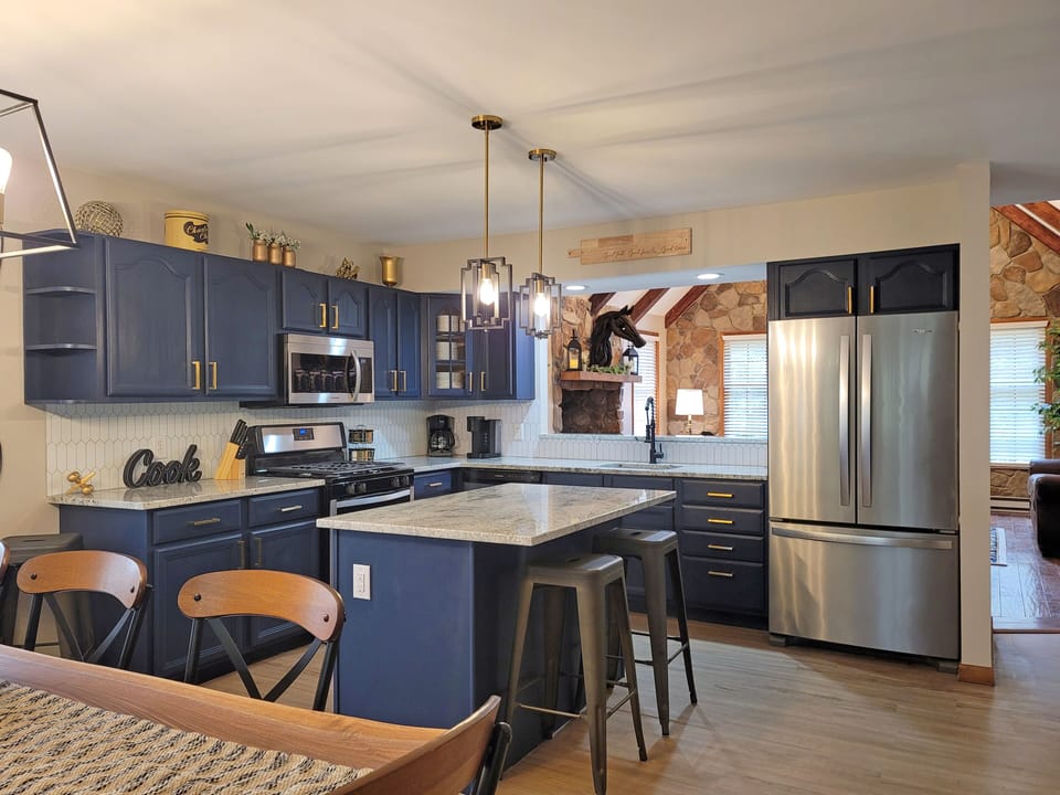 Our gourmet kitchen features bold navy blue cabinets granite counter tops.