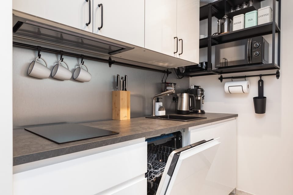 Kitchenette with plenty of kitchen utensils and dishes. 