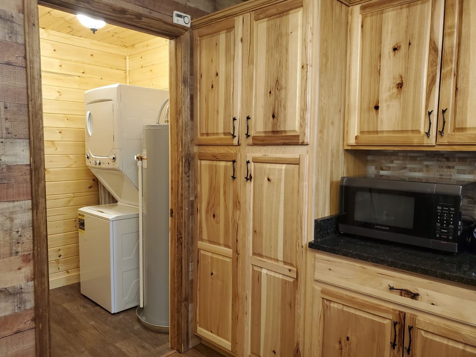 Laundry room with stackable washer and dryer. Large cabinet has board games!