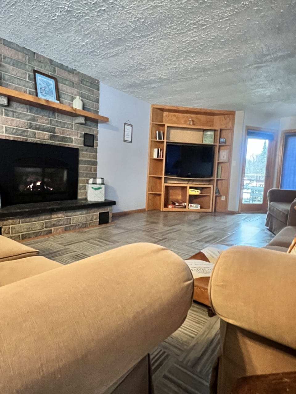 Spacious Living Room with a gas fireplace, entertainment center, patio door