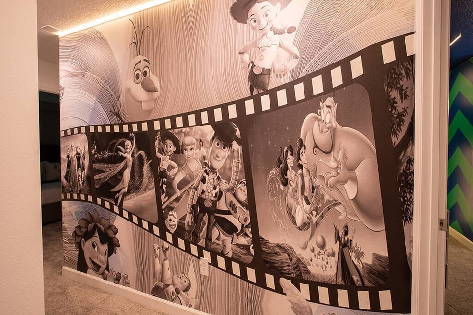 Enter a lively space highlighted by a bold black-and-white filmstrip mural of your favorite animated characters, setting a playful mood for your visit, while soft lighting adds warmth and charm to the welcoming atmosphere.