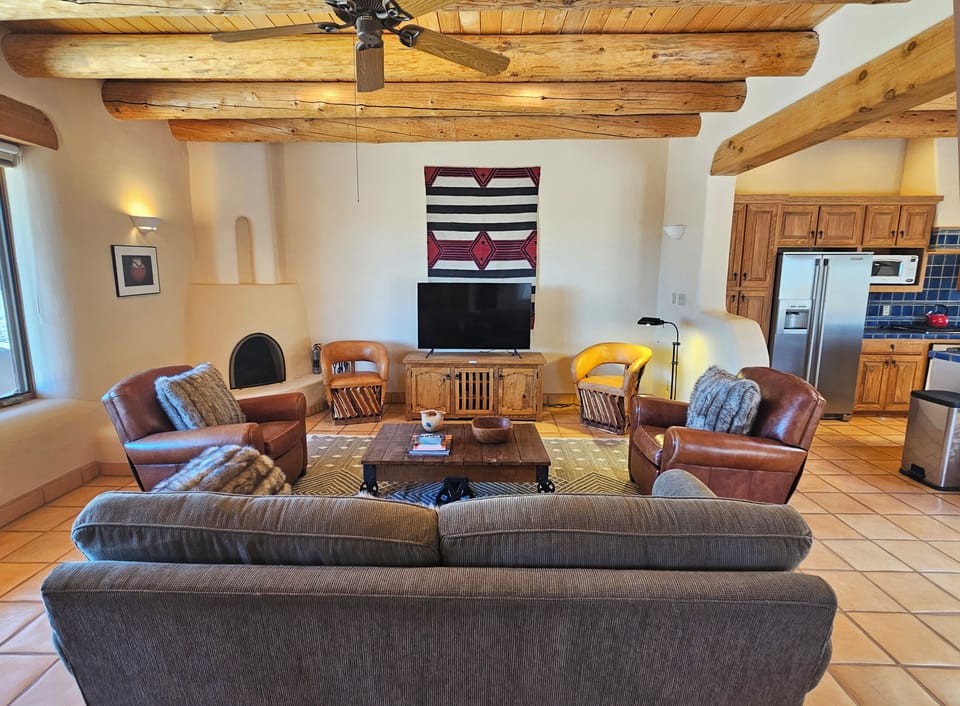 Livingroom with candle only kiva fireplace and large Smart TV.