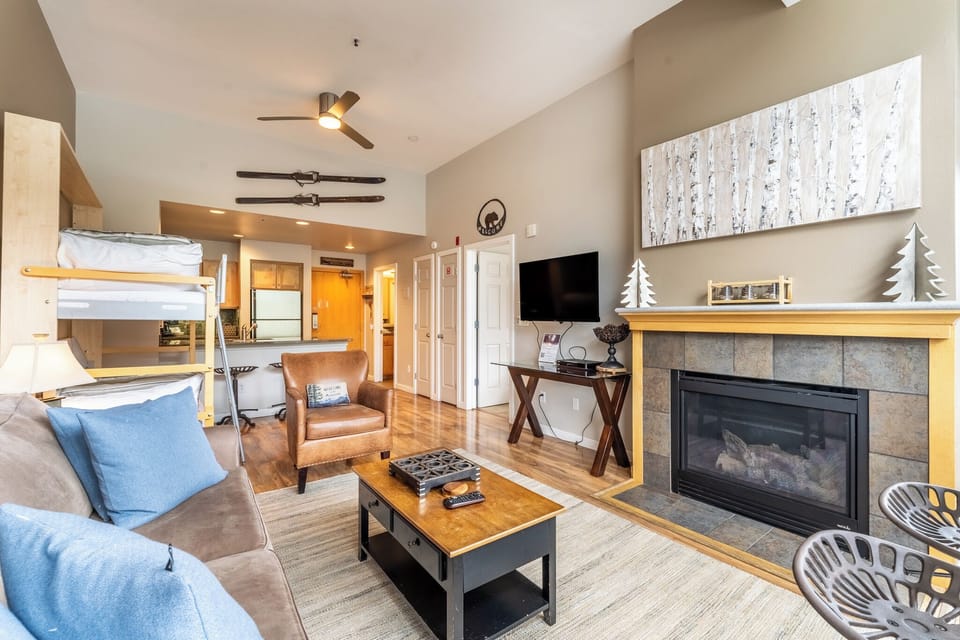 Living room area featuring vaulted ceiling, flat screen TV, gas fireplace, access to the private balcony and gorgeous views overlooking Keystone Lake.