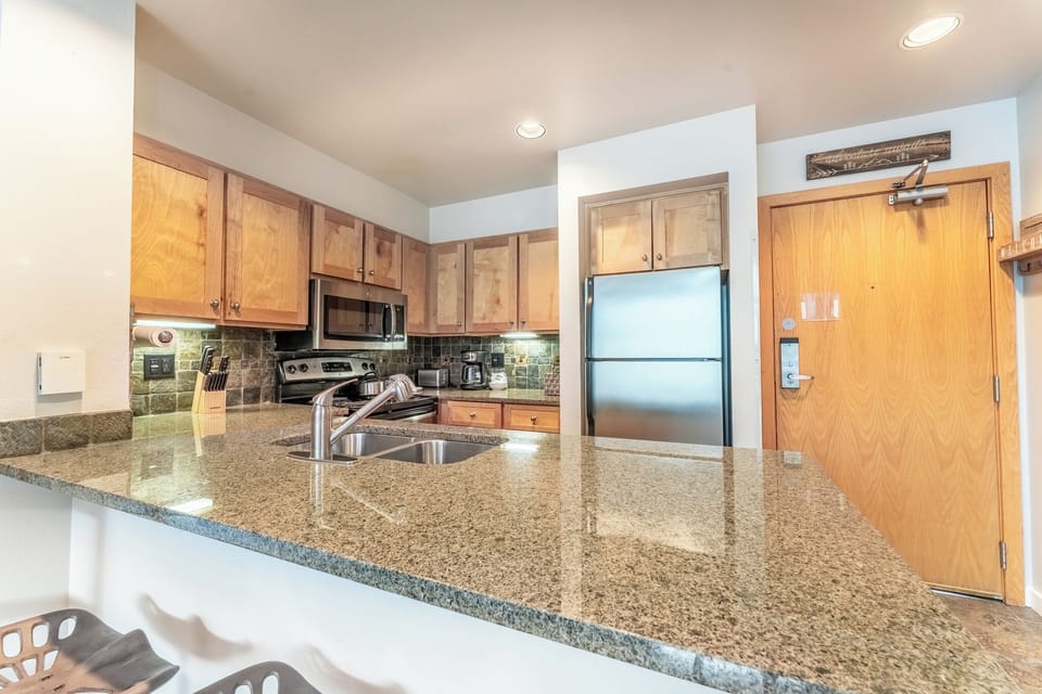 Remodeled full-sized kitchen featuring stainless steel appliances and granite countertops.