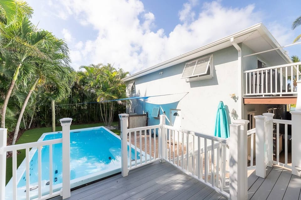 The fenced in backyard is a palm paradise with sunlight and shade. It features an inflatable water park, artificial turf, and a 18x8 swim spa/plunge pool with lounge deck equipped with heater (heats to 104 F)