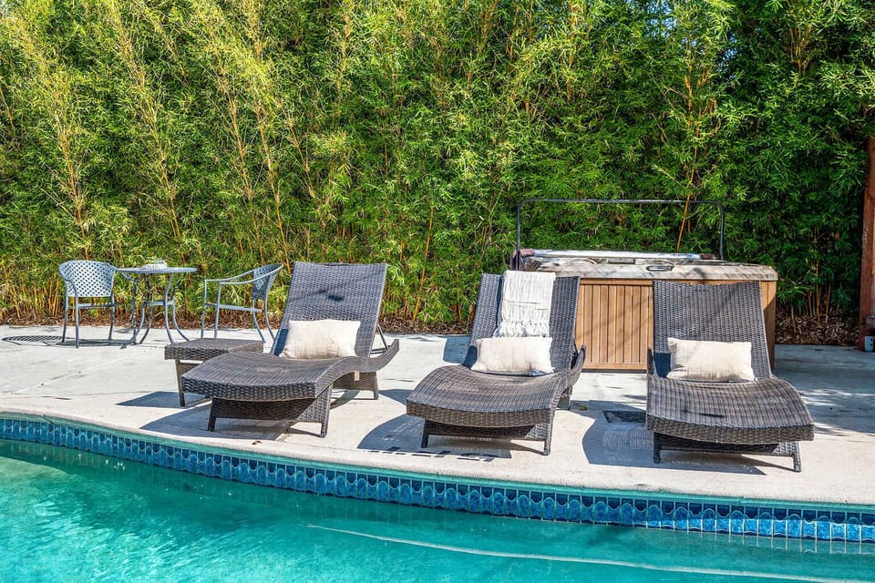 Relax by the pool on comfy loungers or enjoy a quiet moment at the bistro table. With lush greenery and a soothing hot tub nearby, this spot is perfect for unwinding in total comfort.

