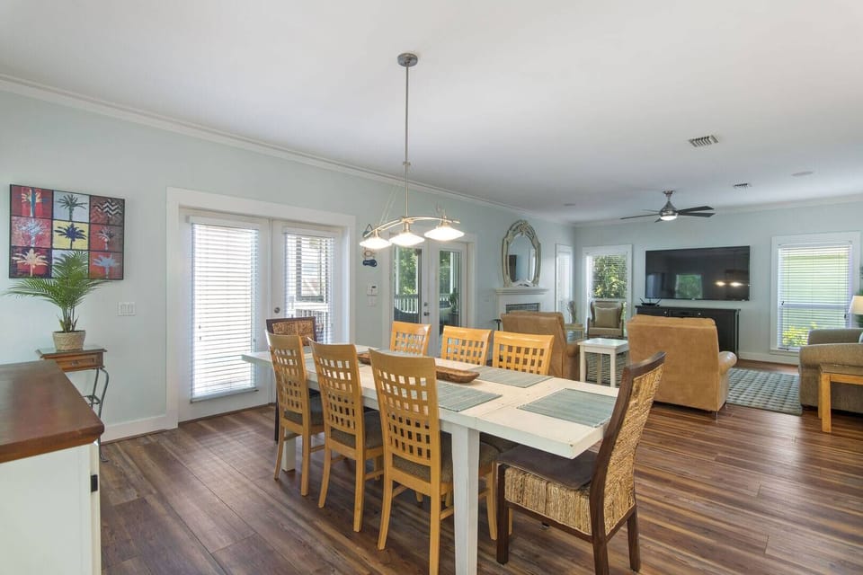 Open dining area w/ farmhouse table flowing into the living space