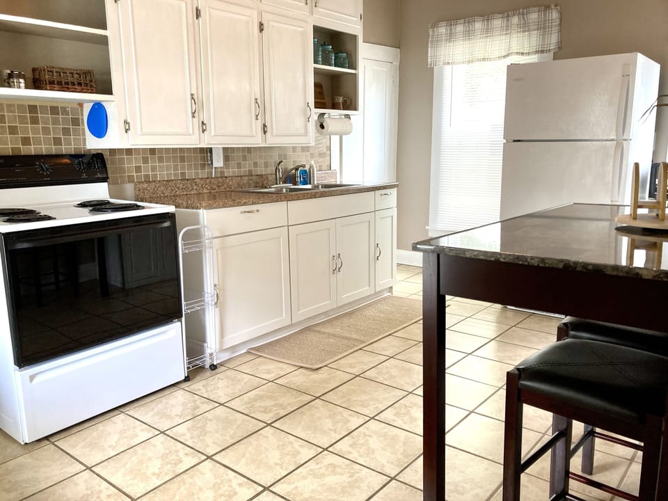 Full kitchen equipped for cooking and baking. Full fridge. Electric stove/oven.