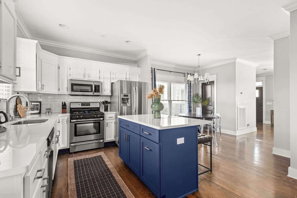 ️ Cook & dine in style! This modern kitchen with a blue island, stainless steel appliances, and open dining area is perfect for gatherings. Enjoy meals in a bright, inviting space! ✨