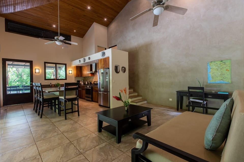 Open living room/kitchen area with high ceilings and ceiling fans