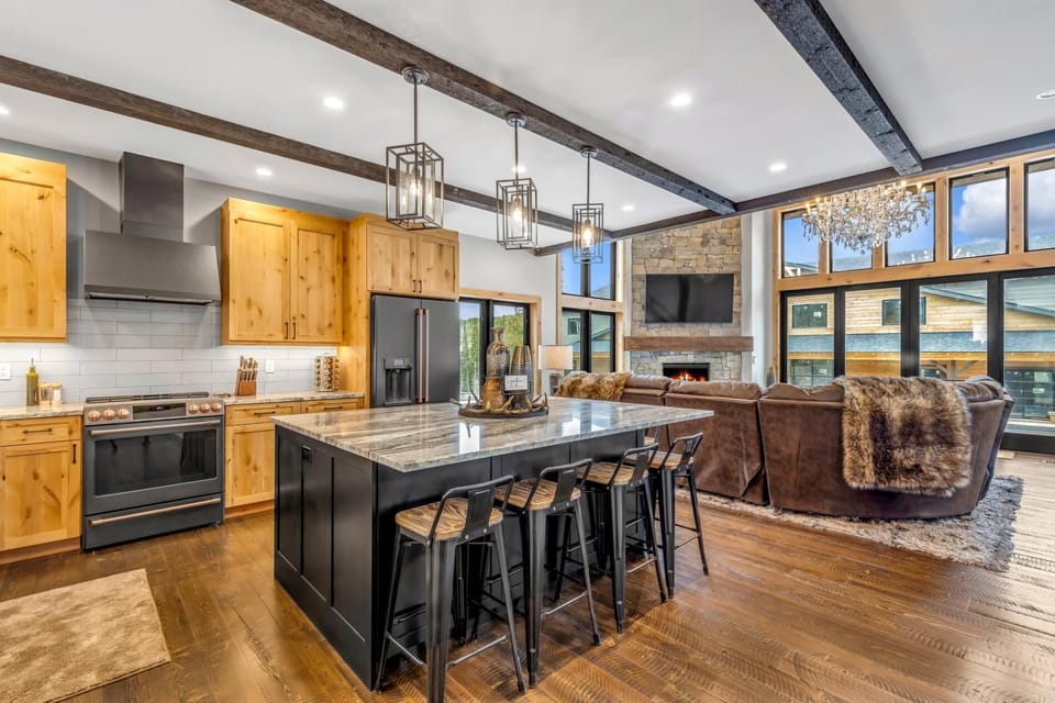 Open concept kitchen, living area, and dining area with fully stocked kitchen, state of the art appliances, breakfast bar seating for 6, and alpine views.