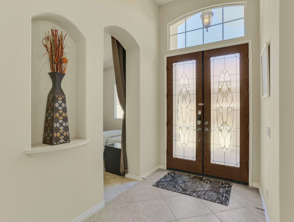 Bright entryway with decorative glass doors and welcoming foyer