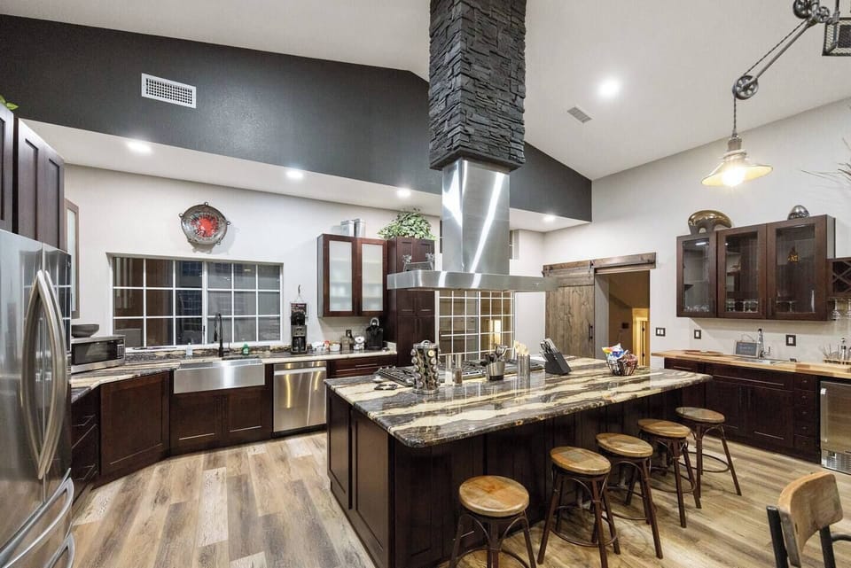 Seating area at custom granite counter surrounding 60” stove. Stoneware dishes and utensils for up to 24 guests, pots & pans for cooking large meals, roaster oven, crockpot, both Keurig & drip coffee makers, grinder, bread maker, etc Just gorgeous!