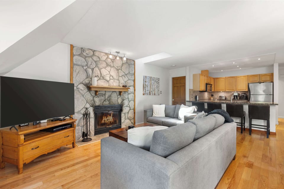 - Inviting living room with stone fireplace and open concept  
- Gather for cozy nights or stream your favorite shows  
- Warm wood details and soft lighting create true comfort  