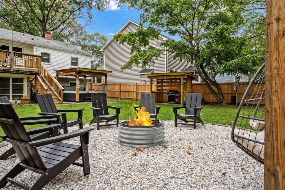 Custom built 8 person fire pit with two hanging egg chairs and firewood!