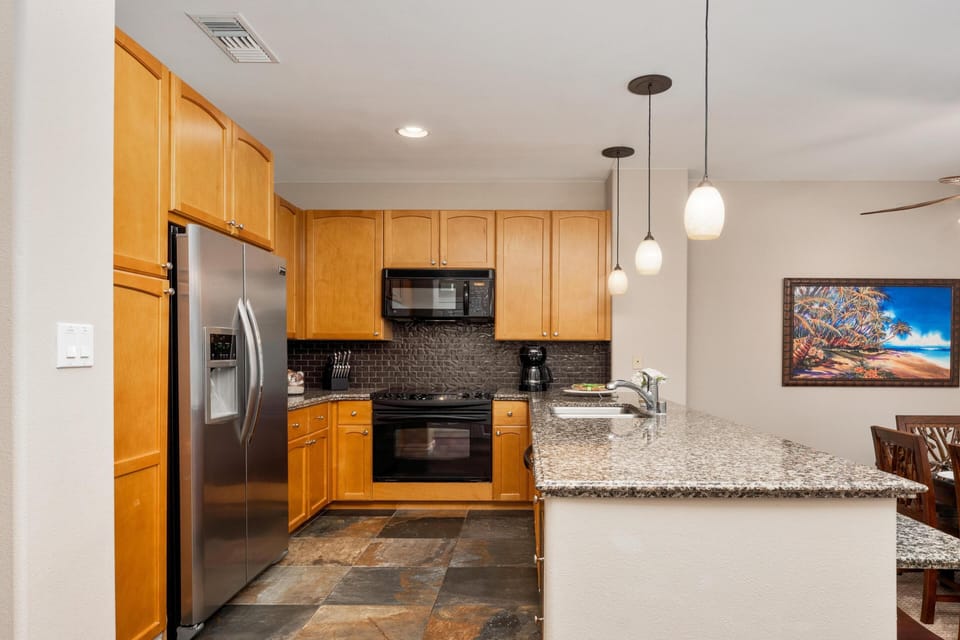 Modern kitchen with granite countertops and stainless steel appliances.