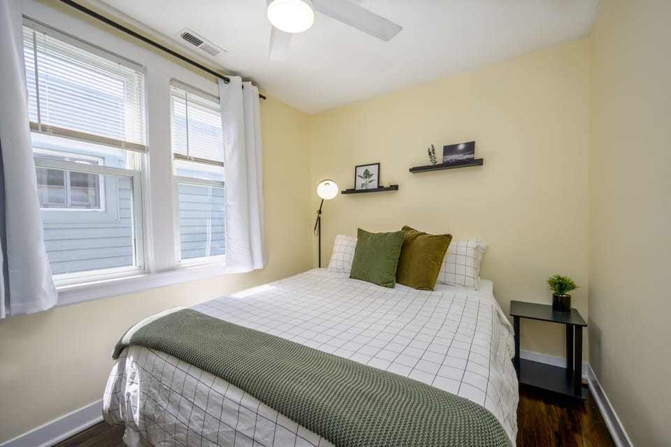 A plush comfortable middle bedroom with desk and ample storage space. 
