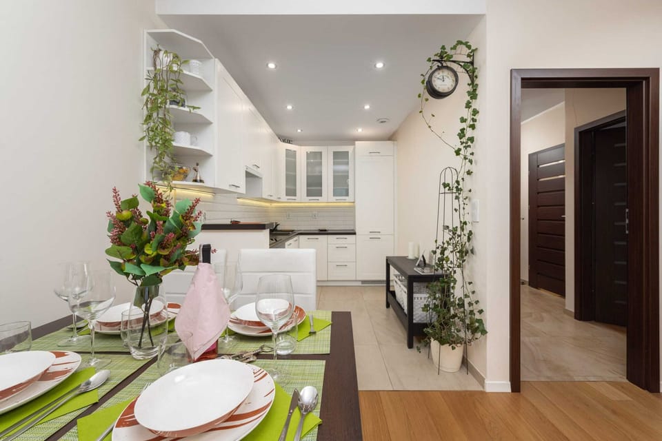 Open-plan kitchen and dining area with decorative plants and modern finishes.
