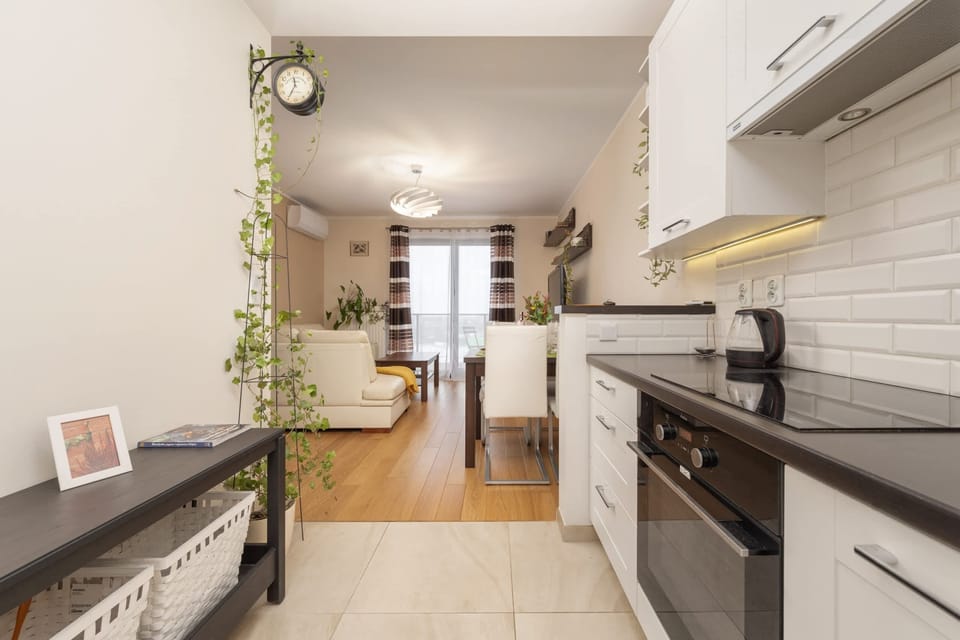 Bright kitchen with white cabinets, clean countertops, and sleek appliances.
