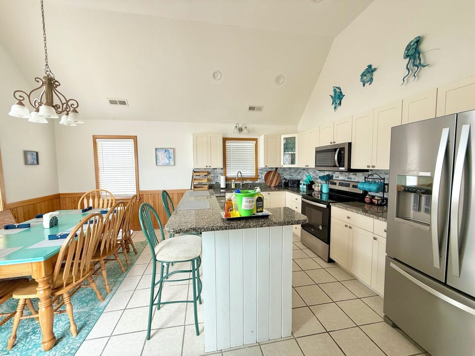 3rd floor fully stocked kitchen off the great room opens to top deck with grill