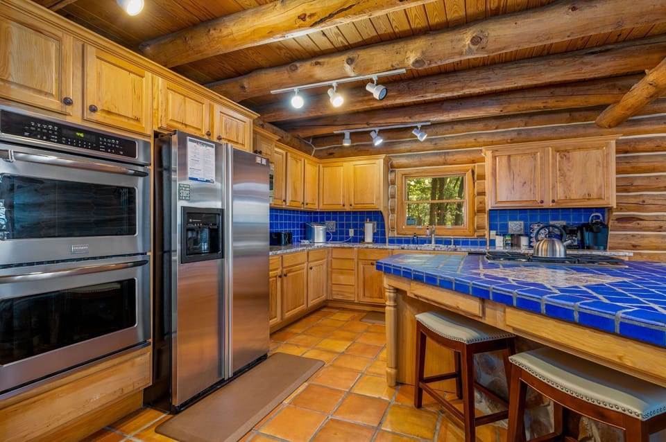 Fully stocked kitchen with a blender, coffee pot, toaster, ice maker, double oven, microwave, pots, pans, dishes, utensils, and plenty of space to feed a crowd. 