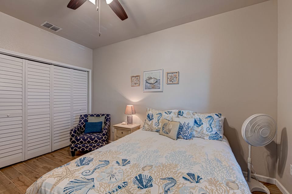Drift off in your coastal-themed bedroom with ocean-inspired linens, charming nautical artwork, and a ceiling fan for perfect comfort.
