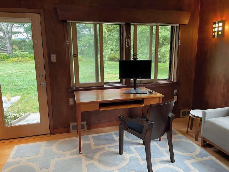 External monitor, cherry desk, standard office supplies, and printer available for guest use.  This space is in the third bedroom/den. The rug in this room has changed since this photo was taken.  It is now solid blue. 