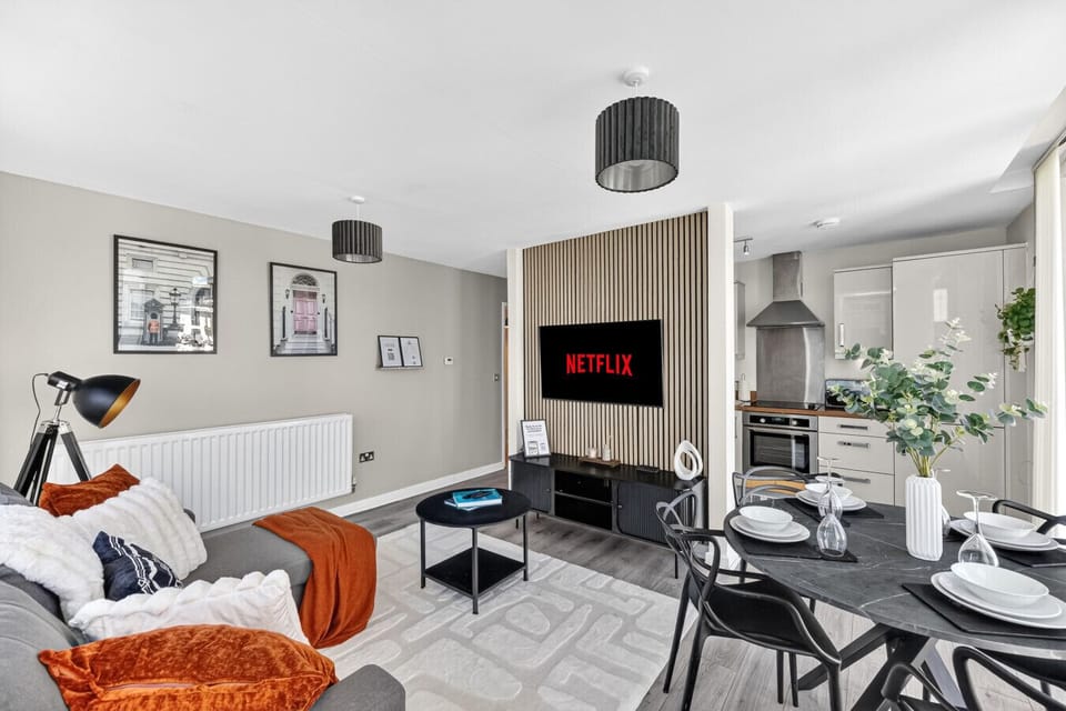 Spacious open-plan living area featuring a 50” smart TV and a plush, comfortable corner sofa, perfect for relaxing.