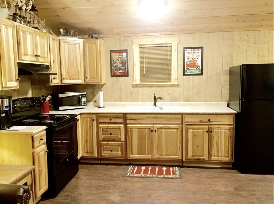 The kitchen is fully stocked with pots, pans, a skillet, cooking utensils & more
