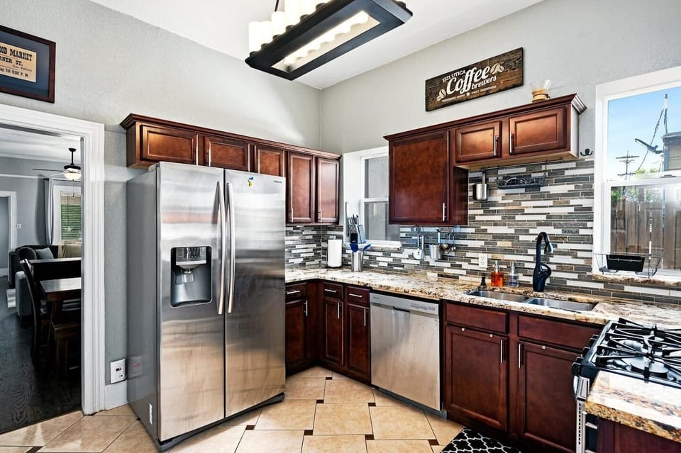- Cook with ease in this well equipped kitchen featuring stainless steel appliances and granite counters
- Dark wood cabinets and a tile backsplash bring depth and character to the space
- Includes coffee bar essentials and all the tools you need