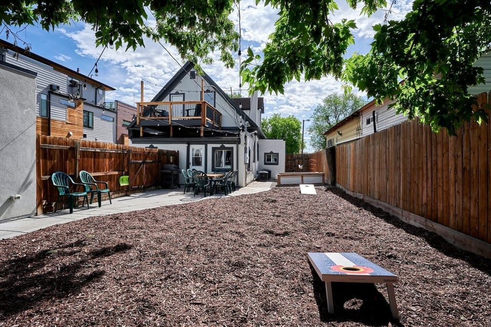 - Stylish backyard with shaded seating, cornhole setup, and string lights
- Plenty of space for games, outdoor meals, and relaxing under the tree canopy
- Enjoy this private fenced yard with direct access to the house and balcony