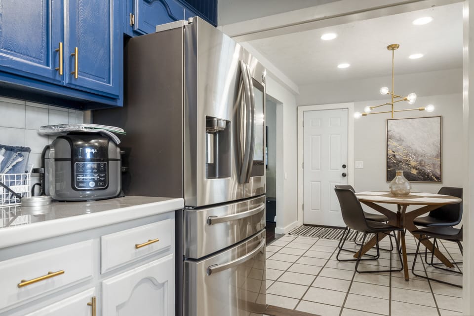 Kitchen with air-fryer and double ovens and electric stove. 