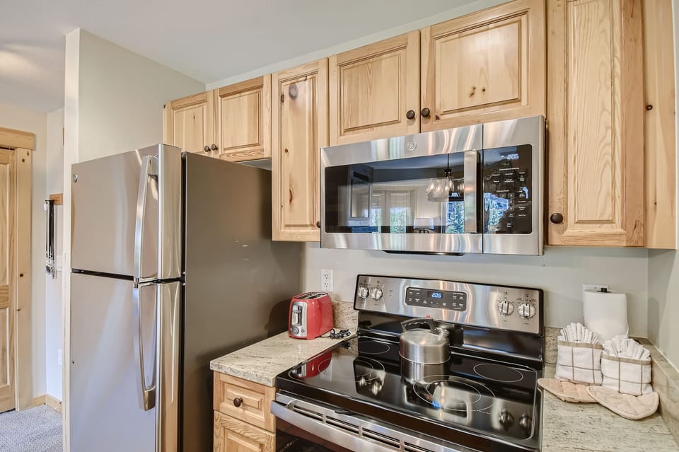 Kitchen with natural stone countertops and SS appliances