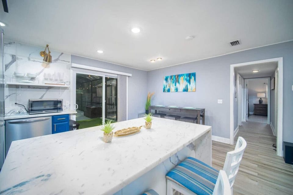 Dine in style with this open and airy space featuring a marble island, modern décor, and easy access to the cool pool cabana~
