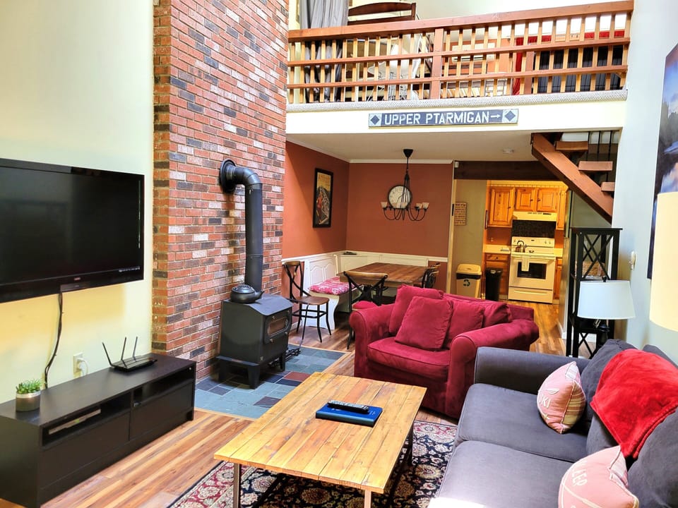 Living area to kitchen with view of child proof railing in loft.