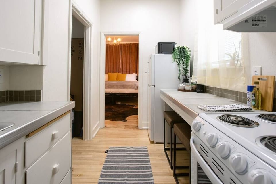 Bright and functional kitchen leading into a cozy bedroom retreat.