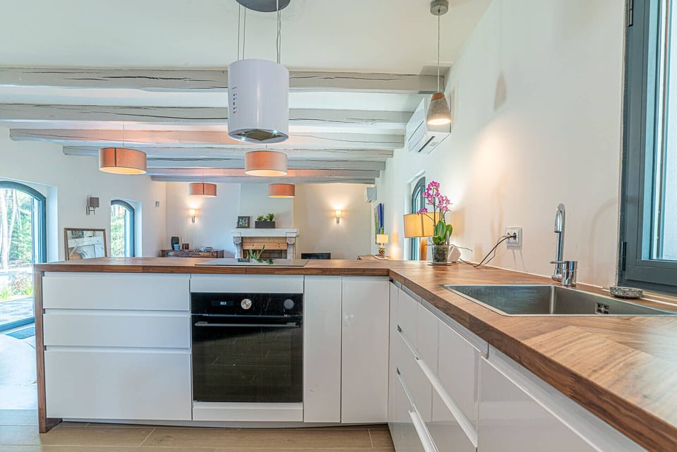 Modern open-plan kitchen with wooden countertops and pendant lighting — Villa Jade, luxury holiday villa in Sintra