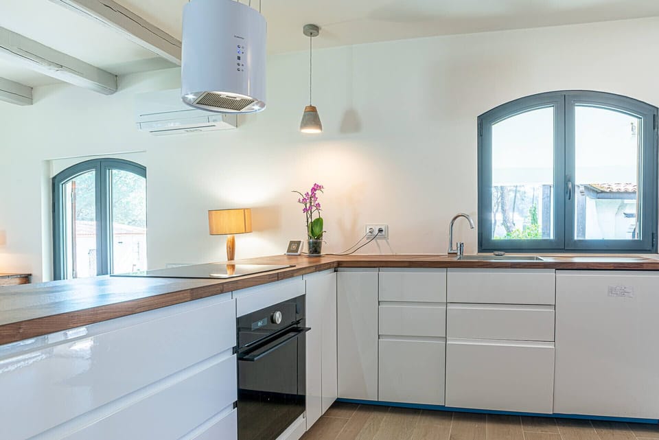 Modern kitchen with white cabinetry and wooden worktops — Villa Jade, luxury holiday villa in Sintra