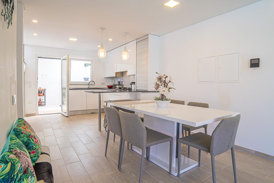 Modern open-plan kitchen-dining room with pendant lighting — Villa Santi, luxury holiday villa in Aroeira