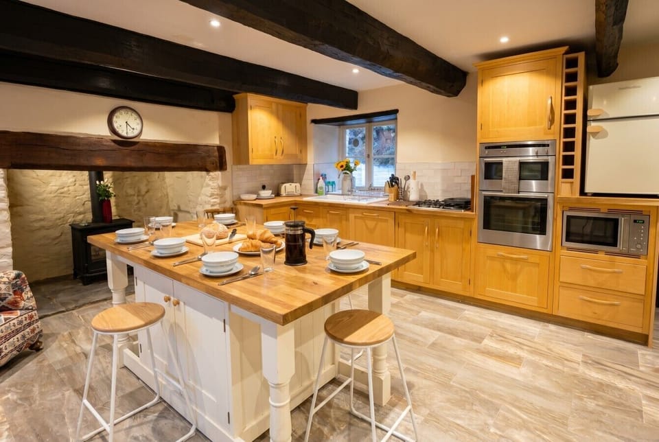 Character beams and a wide fireplace greet you in this sociable family kitchen.