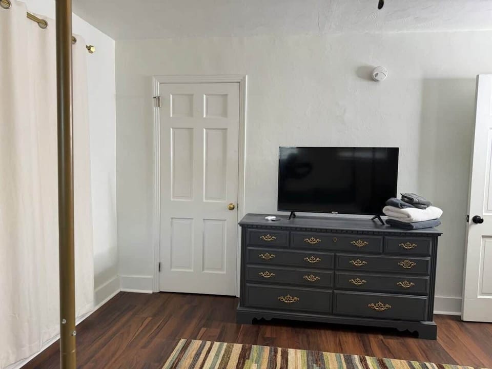 Queen bedroom with storage and smart ROKU TV.