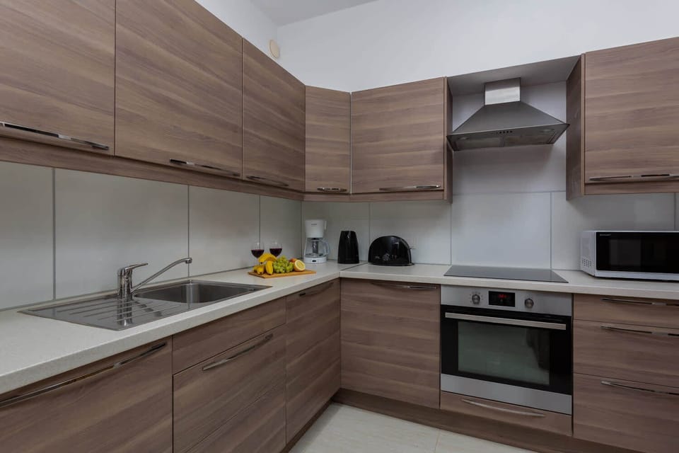 Fully equipped kitchen with wooden cabinets, stainless steel appliances, and a clean design.
