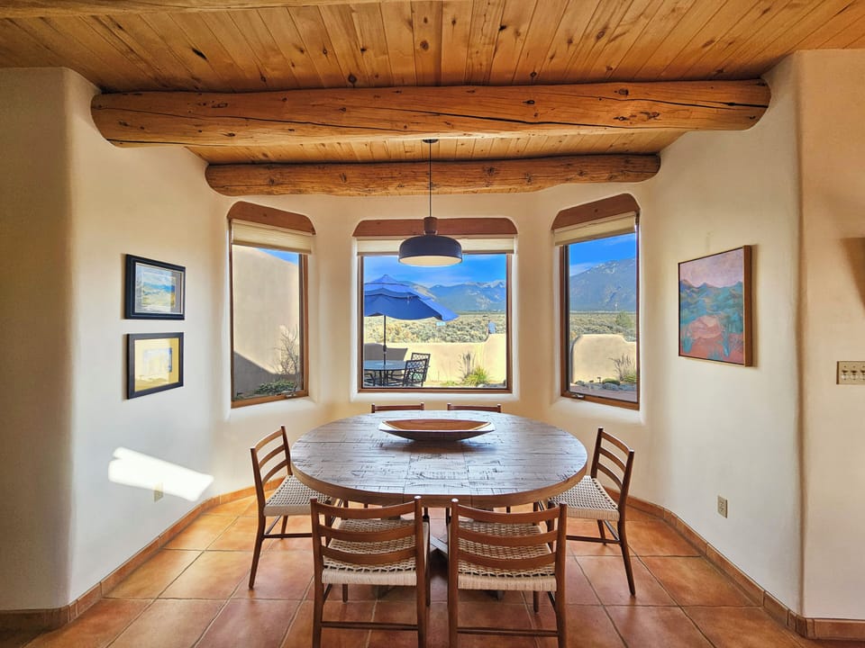 Dining area view from Kitchen looking towards mountains and outdoor dining area.  Large dining table for 6-8.