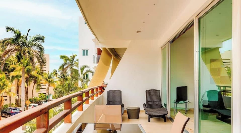 Relax on the spacious balcony with outdoor seating and tropical views.