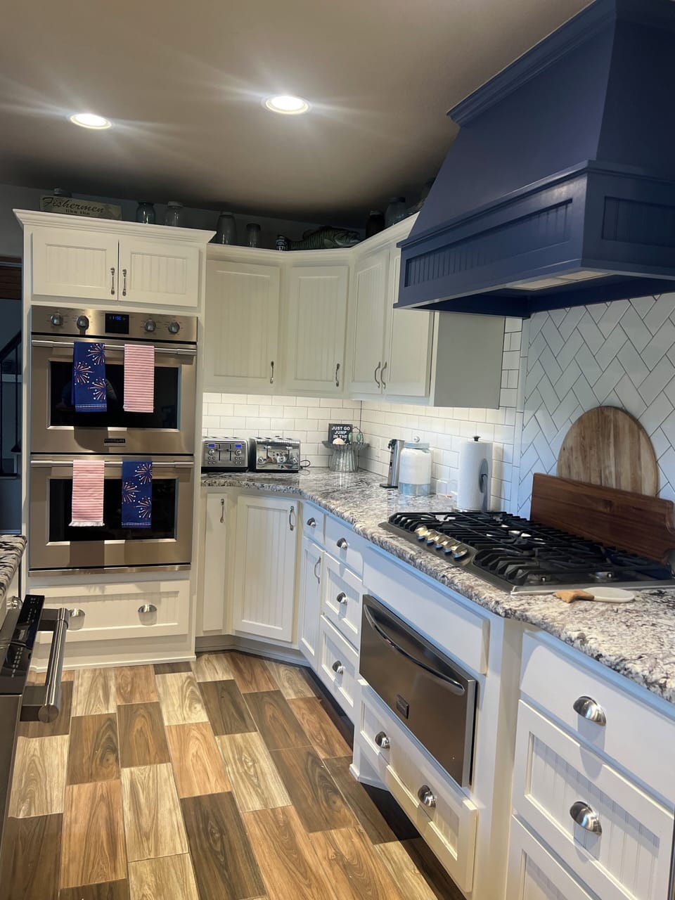 Kitchen with double oven, cooktop and warming drawer.