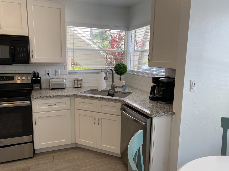 Fully stocked kitchen with small appliances, cook and bakeware.
