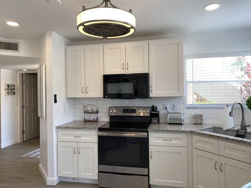 Kitchen with new cabinets, stainless steel appliances and granite countertops.