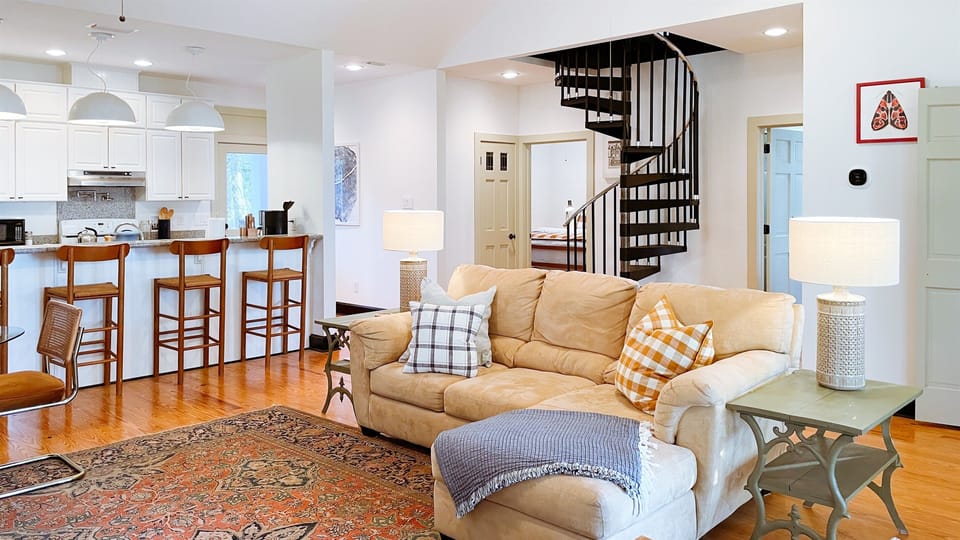 The great room has a big comfy couch and two lounge chairs, all facing the 55in smart tv, which displays works of art when turned off.