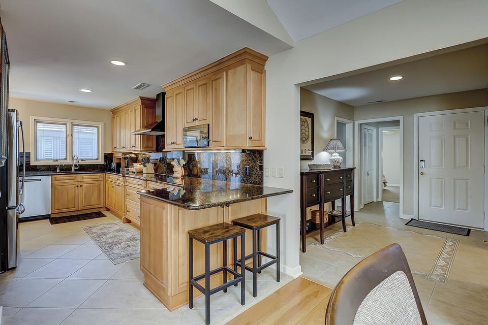 Fully stocked kitchen with 2 barstools for extra seating.
